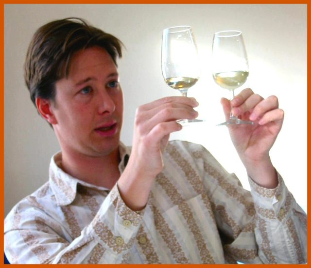Man comparing 2 glasses of white wine
